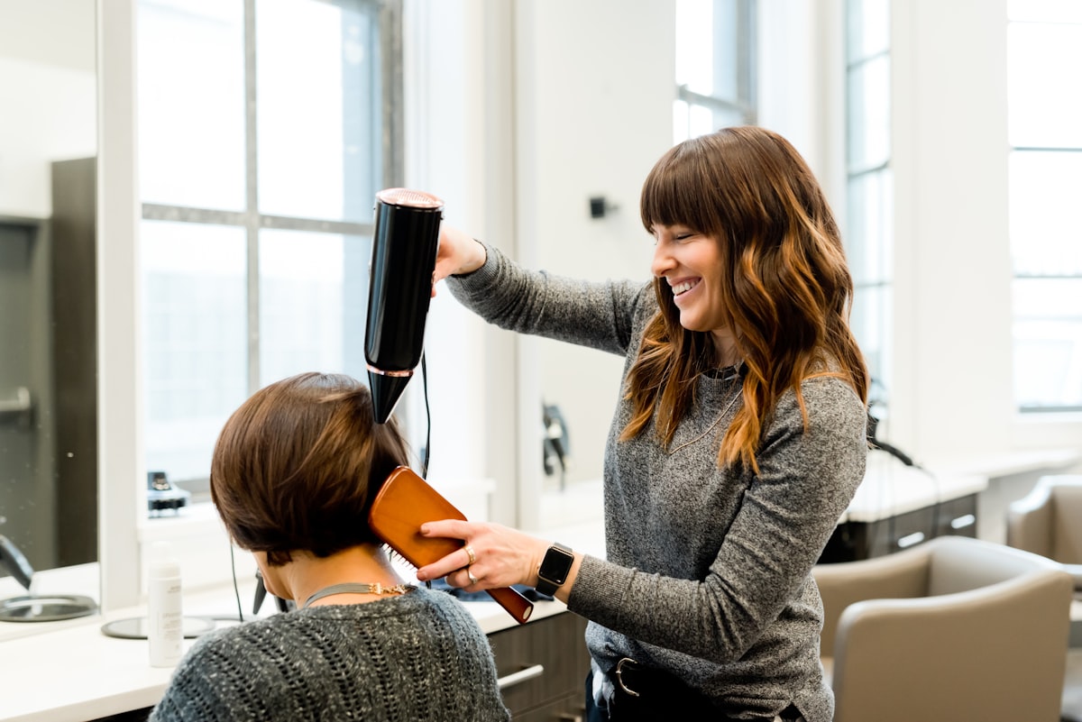 Stylist drying a client's hair in a modern salon